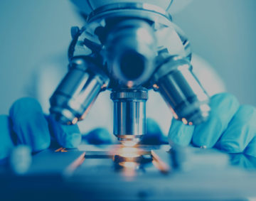 Close up of examining of test sample under the microscope in laboratory.